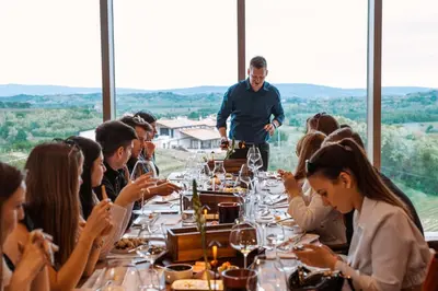a group of people sitting around a table at a restaurant at Posestvo Ščurek wine in Dobrovo