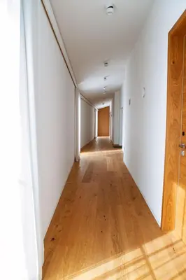 an empty hallway in an apartment with white walls and wooden floors at Posestvo Ščurek wine in Dobrovo