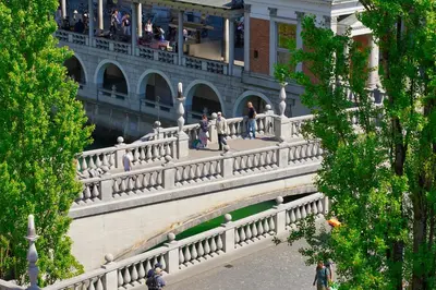 people walking on a bridge in a building at Poet Apartment in Ljubljana