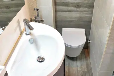 a bathroom with a white sink and a toilet at Poet Apartment in Ljubljana
