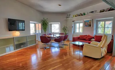 a living room with a couch and a table and chairs at Poet Apartment in Ljubljana