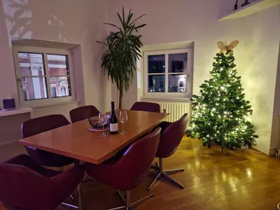 a dining room with a christmas tree and a table at Poet Apartment in Ljubljana