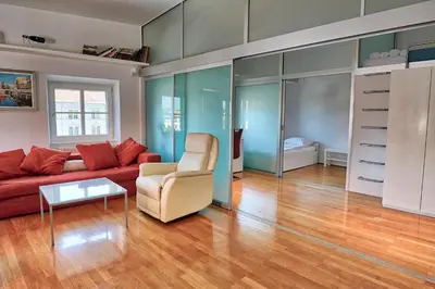 a living room with a red couch and a table at Poet Apartment in Ljubljana
