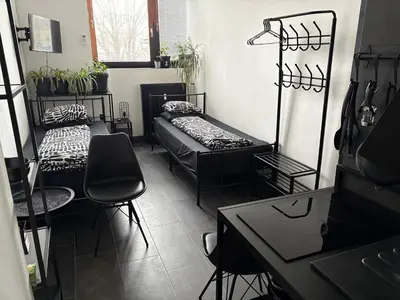 a room with two beds and a table and chairs at INDUSTRIAL ZONE-STUDIO 3 in Ljubljana