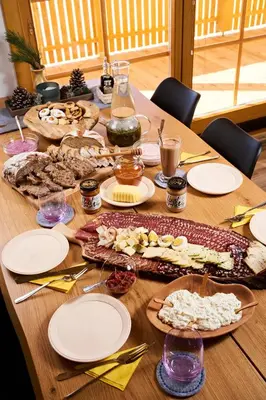 a wooden table with plates of food on it at Cottage Osojnik - Alpine escape with Wellness in Solčava