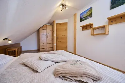 a bedroom with a bed with two pillows on it at Cottage Osojnik - Alpine escape with Wellness in Solčava