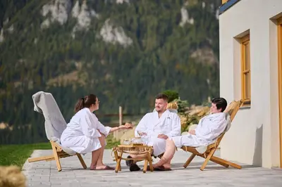a group of people in white robes sitting on a patio at Cottage Osojnik - Alpine escape with Wellness in Solčava