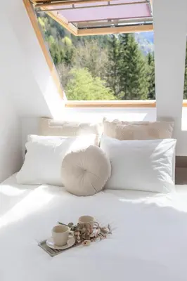 a white bed with two cups and a tray on it at Apartment Lucka, Kranjska Gora in Kranjska Gora