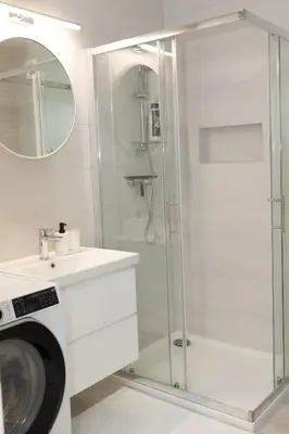 a bathroom with a shower and a sink and a washing machine at Apartment Lucka, Kranjska Gora in Kranjska Gora