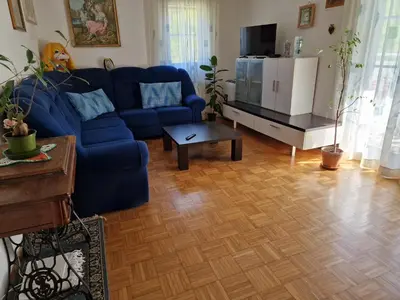 a living room with a blue couch and a table at Apartment Luka at Soča & Koritnica confluence in Bovec