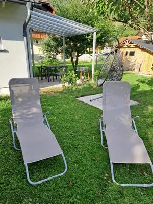 two chairs sitting in the grass in a yard at Bella Apartment in Žirovnica