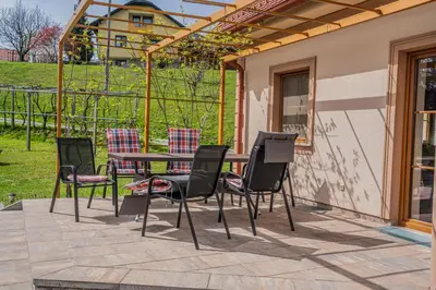 a patio with a table and chairs on a patio at Nedelkova Zidanca in Trnovska Vas