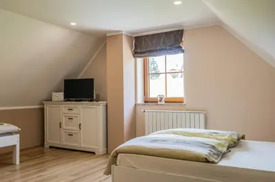 a bedroom with a bed and a tv and a window at Nedelkova Zidanca in Trnovska Vas