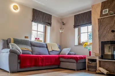 a living room with a couch and a tv at Nedelkova Zidanca in Trnovska Vas