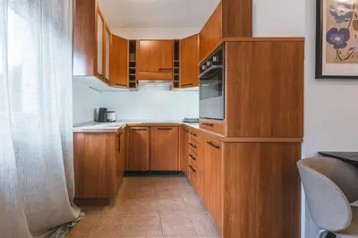 a small kitchen with wooden cabinets and a microwave at House Lenart in Bled
