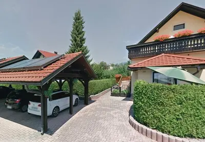 a house with a car parked under a roof at House Lenart in Bled