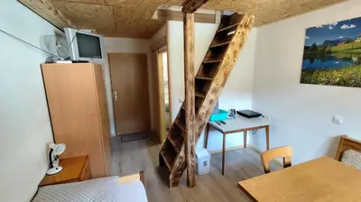 a room with a ladder and a table and a desk at Domačija Markc in Železniki