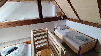 a small room with two bunk beds and a ladder at Domačija Markc in Železniki