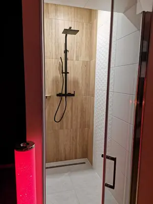 a shower in a bathroom with a red candle at Spa Hera in Šmartno pri Litiji