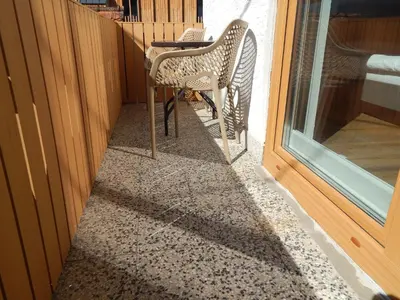 a chair sitting on a porch next to a window at Apartments BB in Bohinj