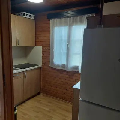 a small kitchen with a refrigerator and a window at Brunarica 30 Terme Čatež in Mostec