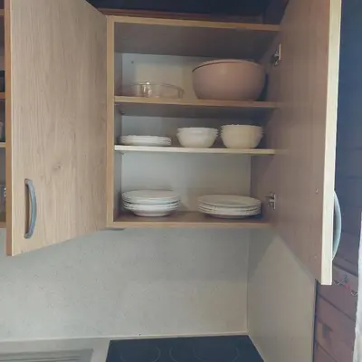 a cupboard with plates and bowls in it at Brunarica 30 Terme Čatež in Mostec
