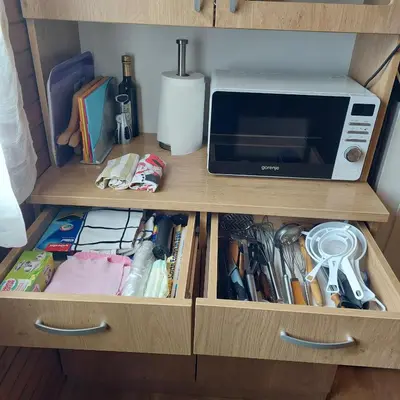 a wooden cabinet with a microwave and other kitchen utensils at Brunarica 30 Terme Čatež in Mostec