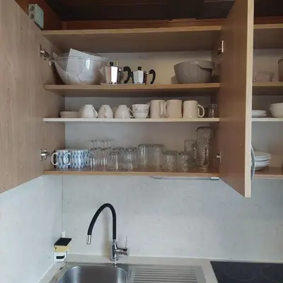 a kitchen with a sink and a shelf with dishes at Brunarica 30 Terme Čatež in Mostec
