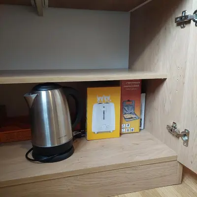 a coffee pot and a box in a cupboard at Brunarica 30 Terme Čatež in Mostec