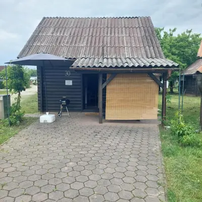 a small house with an umbrella and a patio at Brunarica 30 Terme Čatež in Mostec