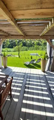 a porch with a bench and a view of a park at Počitniška hiška pri Lipi in Dramlje