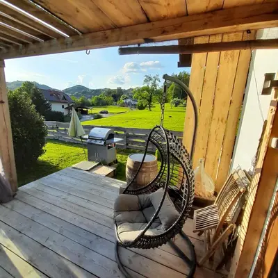 a porch with two chairs and a swing at Počitniška hiška pri Lipi in Dramlje