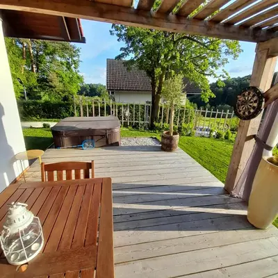 a wooden deck with a table and a grill at Počitniška hiška pri Lipi in Dramlje