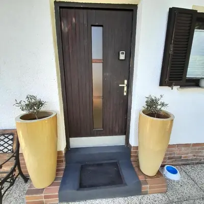 two large vases sitting in front of a door at Počitniška hiška pri Lipi in Dramlje