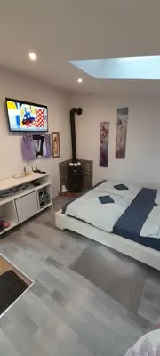 a bedroom with a bed and a flat screen tv at Apartma Lavanda in Dramlje