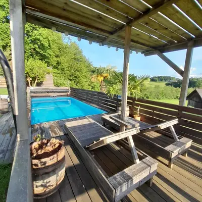 a deck with a swimming pool and a pergola at Glamping pod Hrastom in Dramlje