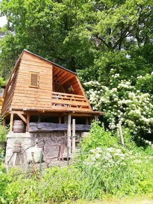 a small wooden house sitting on top of a building at Glamping pod Hrastom in Dramlje