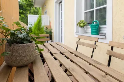 a wooden bench with a potted plant on a balcony at Bled Center modern apartment with big balcony in Bled