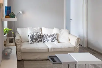 a living room with a white couch with two pillows at Bled Center modern apartment with big balcony in Bled