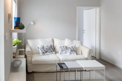a white living room with a couch and a table at Bled Center modern apartment with big balcony in Bled