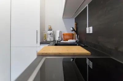 a kitchen counter with a wooden cutting board on it at Bled Center modern apartment with big balcony in Bled