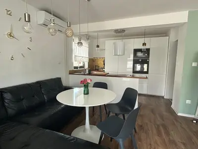 a living room with a couch and a table with chairs at DEKO-apartments in Ljubljana