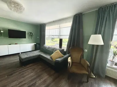 a living room with a couch and a chair at DEKO-apartments in Ljubljana