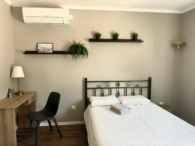a bedroom with a bed and a desk and a chair at DEKO-apartments in Ljubljana