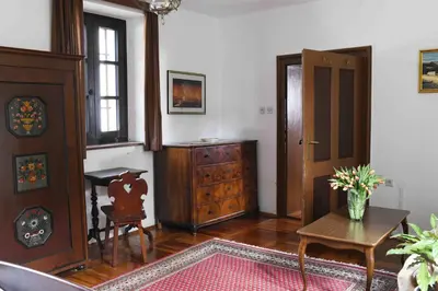 a living room with a table and a wooden cabinet at Resort Vidmar - Baroque villa near Bled in Lesce