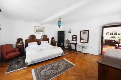 a bedroom with a large bed and a living room at Resort Vidmar - Baroque villa near Bled in Lesce