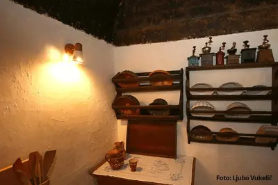 a room with wooden shelves and a table with dishes at Dormouse House in Slovenia in Grahovo