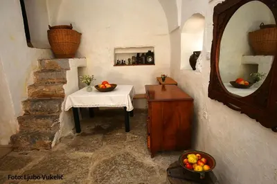 a room with a table and a mirror and a table with fruit at Dormouse House in Slovenia in Grahovo