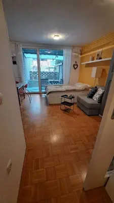 a living room with a bed and a couch at MERY Studio in Ljubljana