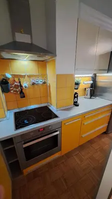 a kitchen with yellow cabinets and a stove top oven at MERY Studio in Ljubljana